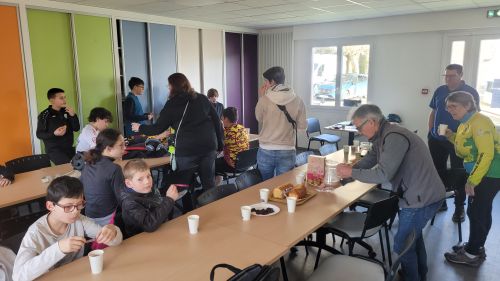 Les jeunes autour des tables boivent un verre de jus de fruit et mangent des gateaux